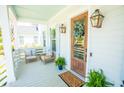 Inviting front porch with seating, a decorative wreath, and stylish outdoor decor at 3688 Goodwater St, Mount Pleasant, SC 29466