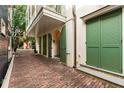 Exterior shot featuring a brick-paved walkway, balcony, with shutters and an arched entry, exuding classic elegance at 4 Catfiddle St, Charleston, SC 29403