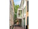 Exterior view showcasing brick-paved path, classic architecture, and inviting balcony, complete with timeless charm and curb appeal at 4 Catfiddle St, Charleston, SC 29403