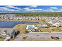 Community aerial view of pool and surrounding new home construction and pond at 404 Snowy Plover Ln, Summerville, SC 29486