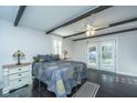 Bright bedroom with dark wood floors, ceiling beams, and french doors to the outside at 4515 Holmes Ave, North Charleston, SC 29405