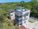 Aerial view of the property showcasing its three floors, rooftop deck, screened porches, and surrounding landscape at 4637 Bonnie Marie Way, North Charleston, SC 29405