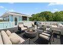 Luxurious rooftop deck with comfortable seating, a built-in bar, and a cozy fire pit at 4637 Bonnie Marie Way, North Charleston, SC 29405