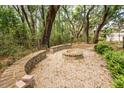 Serene backyard featuring a fire pit area surrounded by lush greenery and mature trees at 4991 Sound View Dr, Mount Pleasant, SC 29466