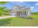 Charming two-story home with a well-manicured lawn, a two-car garage, and a welcoming front porch at 5032 Ballantine Dr, Summerville, SC 29485