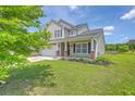Charming two-story home with a well-manicured lawn, a two-car garage, and a welcoming front porch at 5032 Ballantine Dr, Summerville, SC 29485