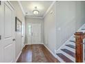 Traditional foyer with hardwood floors, staircase, and decorative rug leading to the white front door at 508 Alderly Dr, Moncks Corner, SC 29461