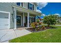 Inviting front porch adorned with colorful flowers and an American flag, offering a cozy outdoor space at 511 Nandina Dr, Goose Creek, SC 29445