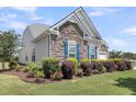 Well-maintained home featuring stone detail, lush landscaping and vibrant blue shutters at 522 Tidewater Chase Ln, Summerville, SC 29486