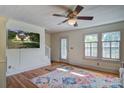 Cozy living room with hardwood floors, ceiling fan, television, and lots of natural light at 5615 Highway 165, Ravenel, SC 29470