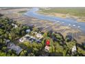 An aerial view of a quaint neighborhood nestled among lush greenery, showcasing waterfront access and stunning marsh views at 5655 Captain Kidd Rd, Hollywood, SC 29449
