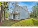 A charming home with a large covered front porch and white columns, surrounded by a lush green lawn and mature trees at 5655 Captain Kidd Rd, Hollywood, SC 29449