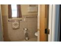 Neutral tiled bathroom with window and white wicker storage shelf at 107 Kelly St, Walterboro, SC 29488