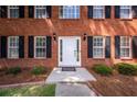 Close up of front door with sidelights, black sconces, and dark mulch landscape at 107 Spalding Cir, Goose Creek, SC 29445