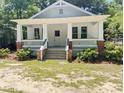 Charming white craftsman-style home with a welcoming front porch and manicured landscaping at 107 Tracy St, Walterboro, SC 29488
