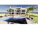 Expansive backyard featuring a stunning pool area with lounge chairs, palm trees, and stylish outdoor furniture at 11 Tabby Ln, Isle of Palms, SC 29451