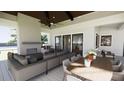 Inviting covered patio with a fireplace, comfortable seating, a dining table and ceiling fan at 11 Tabby Ln, Isle of Palms, SC 29451