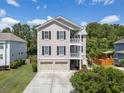 Inviting three-story house featuring double porches and a two-car garage at 118 Wando Reach Rd, Wando, SC 29492