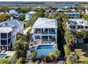 A beautiful modern home with a backyard pool surrounded by lush green landscaping at 124 Charleston Blvd, Isle of Palms, SC 29451