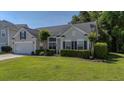 Charming single-Gathering home features manicured lawn, trimmed hedges, and two-car garage at 124 Corral Cir, Summerville, SC 29485