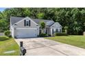 Well-maintained home with a two-car garage, manicured lawn, and mature landscaping at 124 Corral Cir, Summerville, SC 29485