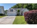 Traditional home with a well-maintained lawn, an attached two-car garage, and established landscaping at 124 Corral Cir, Summerville, SC 29485