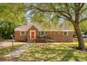 Beautiful brick home featuring a red front door, a small porch, and a well-maintained yard at 13 Charlestowne Rd Rd, Charleston, SC 29407