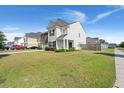 Charming two-story house showcasing manicured front lawn, complemented by a mix of brick and shingle siding at 131 Beargrass Ln, Summerville, SC 29486