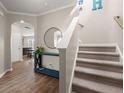 Open foyer showcasing a staircase, hardwood floors, stylish console table, and an arched entryway at 131 Beargrass Ln, Summerville, SC 29486