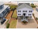 Well-maintained two-story house with a beautifully landscaped yard and paved driveway at 1404 Palmetto Blvd, Edisto Beach, SC 29438