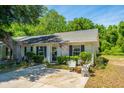 Cozy home with a well-maintained front yard, decorative seating, and lush greenery at 1571 Blaze Ln, Charleston, SC 29412