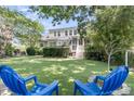 Expansive backyard with lush lawn, mature trees, and outdoor seating; perfect for relaxation at 1733 James Basford Pl, Mount Pleasant, SC 29466