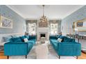 Beautiful living room with blue sofas, a fireplace, elegant wallpaper, and lots of natural light at 184 Ashley Ave, Charleston, SC 29403