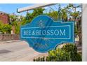 Stylish 'Bee & Blossom' sign outside of a business with foliage and a brick building in the background at 184 Ashley Ave, Charleston, SC 29403