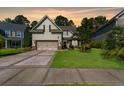 Charming home boasts a well-kept lawn, mature trees, and a two-car garage, set against a picturesque sunset backdrop at 204 Black Gum Cir, Moncks Corner, SC 29461