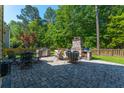 Outdoor patio with a stone fireplace, grill, and dining table, perfect for entertaining and relaxation at 204 Black Gum Cir, Moncks Corner, SC 29461