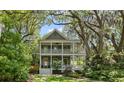 Charming two-story home with double porches surrounded by lush greenery and mature trees at 2187 Saint James Dr, Charleston, SC 29412