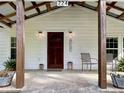 Welcoming front porch with seating and dark wood support beams at 224 Reeves St, Reevesville, SC 29471