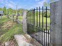 Rustic wooden fence with an ornate wrought-iron gate leading to the property at 224 Reeves St, Reevesville, SC 29471