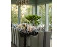 Elegant dining room with large windows, sophisticated decor, and a beautifully set table at 2538 Helmsman Rd, Johns Island, SC 29455