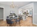 Bright dining area next to a modern kitchen features a glass table and modern chandelier at 301 Beaufort St, Summerville, SC 29483