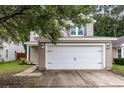 Attached two-car garage with a white door, complemented by light beige siding and mature landscaping at 3844 Annapolis Way, Ladson, SC 29456