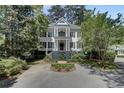 Two-story home featuring a double balcony, manicured landscaping, and circular driveway for curb appeal at 418 W Carolina Ave, Summerville, SC 29483