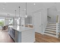 Bright kitchen with an island, hardwood floors, and a staircase in a single-Gathering house at 539 Cooper Village Ln, Mount Pleasant, SC 29464