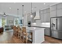 Modern kitchen with stainless steel appliances, a large island with bar seating, and stylish pendant lighting at 539 Cooper Village Ln, Mount Pleasant, SC 29464