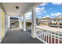 Inviting front porch with white columns and railings, offering a view of the neighborhood at 55 Maple St, Charleston, SC 29403