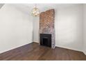 Bright room featuring hardwood floors, a brick fireplace, modern light fixture and neutral walls at 55 Maple St, Charleston, SC 29403