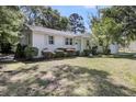 Charming white home featuring lush landscaping and a manicured lawn at 710 W Harrison Rd, Charleston, SC 29407
