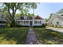 Charming home featuring a covered porch, manicured lawn, and delightful curb appeal at 81 Avondale Ave, Charleston, SC 29407