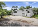 White waterfront home with ample parking, featuring a garage and additional space for vehicles, nestled by a river at 8487 Parkers Ferry Rd, Adams Run, SC 29426